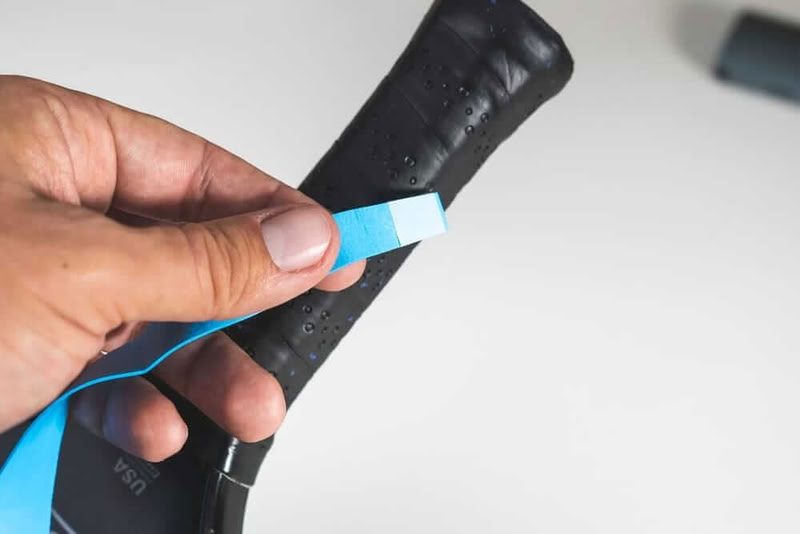 Bắt đầu cuốn từ dưới lên, đặt đầu thon nhỏ của dây quấn vào điểm cuối cùng của cán vợt